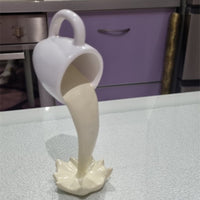 Sculpture de tasse volante avec liquide qui se renverse. Décoration en résine